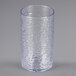 A clear plastic tumbler with a pebble optic design and a blue rim.