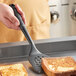 A person using an OXO Good Grips black nylon spatula to lift toast off a plate.