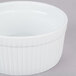 A CAC white china fluted souffle bowl on a gray surface.