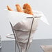Fried chicken in a Bagcraft Packaging white paper cone basket liner in a metal cone basket.