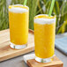 Two glasses of Fanale mango syrup mixed with orange juice with straws.