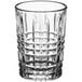 A clear Acopa shot glass with a checkered pattern.