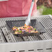 A person using Mr. Bar-B-Q non-stick grill basket to cook food on a grill.
