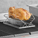 A cooked chicken on a Fox Run chrome adjustable roasting rack.