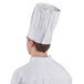 A person wearing a white Chef Revival European chef hat.
