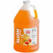 A jug of orange Carnival King Peach Slushy syrup.