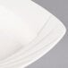 A close up of a CAC white porcelain square soup plate with a wavy edge.