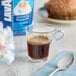 A glass cup of Lavazza Dek decaf espresso on a blue cloth with a spoon.