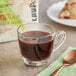 A glass cup of Lavazza Organic Tierra! Alteco coffee with a spoon on a napkin.