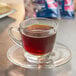 A glass cup of Lavazza Gran Riserva coffee on a saucer.