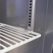 A metal shelf with a metal rack in a Turbo Air undercounter refrigerator.