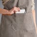 A woman wearing an Acopa Hazleton canvas bib apron with pockets.
