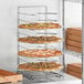 A GI Metal pizza rack with pizzas on it.