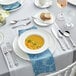A table set with a bowl of soup and Acopa Ophelia stainless steel silverware.