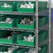 A metal shelving unit with green Regency shelf bins.