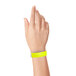A close-up of a hand with a Carnival King highlighter yellow wristband.