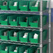 A shelf with Regency green plastic bins filled with white objects.
