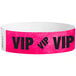 A pink paper wristband with the black text "VIP" and a white border.