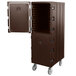 A dark brown plastic Cambro double compartment tray and sheet pan carrier with wheels and a door open.