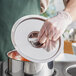 A person wearing gloves places a Choice stainless steel bain marie cover on a pot.
