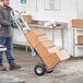 A man using a Lavex convertible hand truck to move boxes.