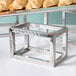 An American Metalcraft stainless steel display riser set with croissants and pastries on it on a table.
