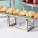 A row of croissants on a hammered stainless steel riser set.