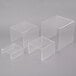 A set of three clear acrylic risers on a white surface.