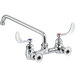 A chrome Waterloo wall-mounted faucet with silver wrist handles and a 12" swing spout.