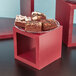 A plate of brownies on a set of mahogany wood display risers.
