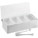 A Tablecraft stainless steel condiment bar with four white plastic inserts and tongs on a white background.