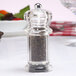A Chef Specialties acrylic pepper mill with a bowl of food on the side.
