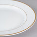 A close up of a CAC porcelain plate with gold trim.