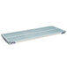 A white rectangular MetroMax metal shelf with blue open grid mat.