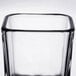 A clear glass Libbey Cube votive holder with a black rim.