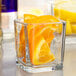 A Libbey glass container with orange slices in it.