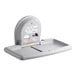 A Koala Kare grey horizontal surface-mounted baby changing station with a stainless steel inset.