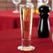 A Libbey Catalina flute filled with liquid on a table.