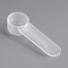 A clear plastic 1.25 cc polypropylene scoop with a short handle resting on a gray surface.