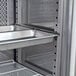 A stainless steel Avantco shelf rail on a metal tray in a refrigerator.