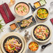 Acopa Ugoki melamine plates with food and chopsticks on a table in an Asian cuisine restaurant.