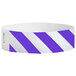 A close up of a purple and white striped Carnival King paper wristband.