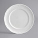 An Acopa Condesa white porcelain plate with a scalloped edge.