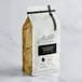 A bag of Arrosto Colombian Supremo whole bean coffee on a marble surface with a label.