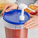 A person's hands using a blue Choice pump lid to dispense liquid into a container.