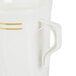 A close up of a Fineline ivory plastic coffee mug with yellow gold stripes on the handle.