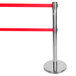 A chrome crowd control stanchion with dual red belts on silver bases.