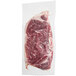 A Rastelli's Black Angus New York strip steak in a plastic package on a white surface.