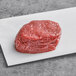 A Rastelli's raw filet mignon steak on a white surface.