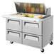 A stainless steel Turbo Air sandwich prep table with 4 drawers and a large food tray with vegetables in it.